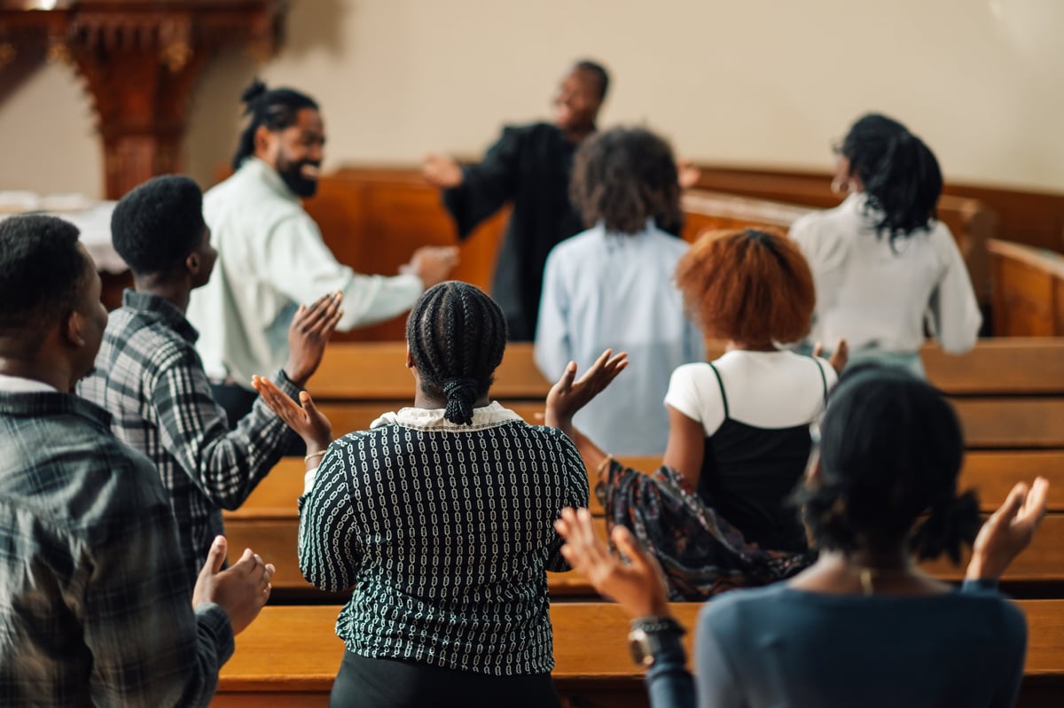 Congregation worshipping together in church, raising hands in praise